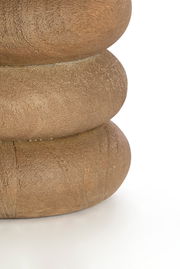 Nahaufnahme eines Lampenfußes aus Holz mit runder, geschichteter Struktur, seitliche Perspektive.