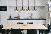 Moderne Hängeleuchte MAXY in einer stilvollen Küche, aus der Perspektive über einem Esstisch hängend.