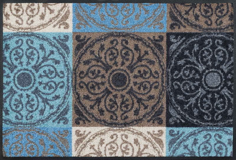 Fußmatte mit dekorativem, mehrfarbigem Muster in Blau-, Braun- und Beigetönen, von oben betrachtet.