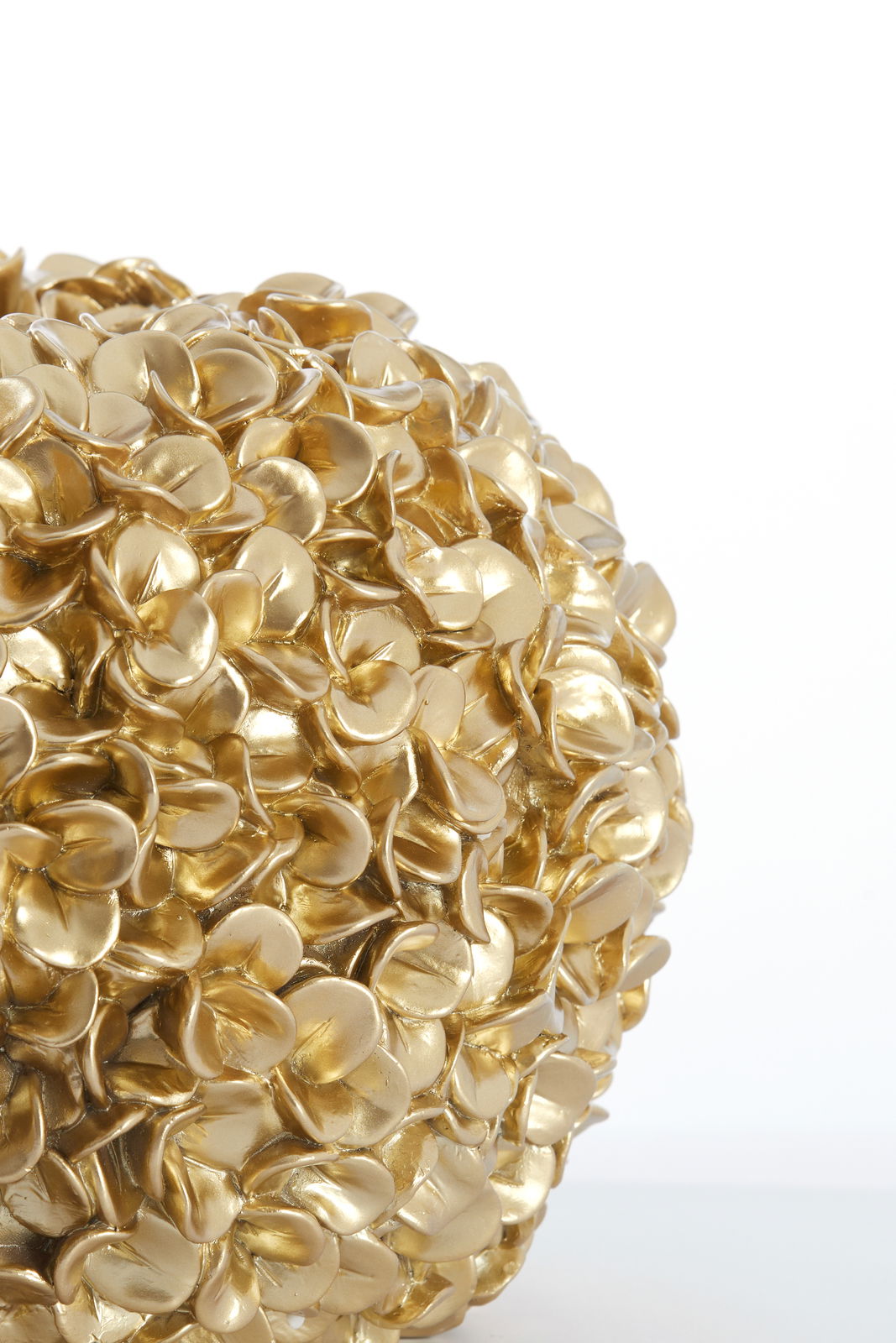 Nahaufnahme einer goldenen Vase mit blütenförmiger Struktur, seitliche Perspektive.