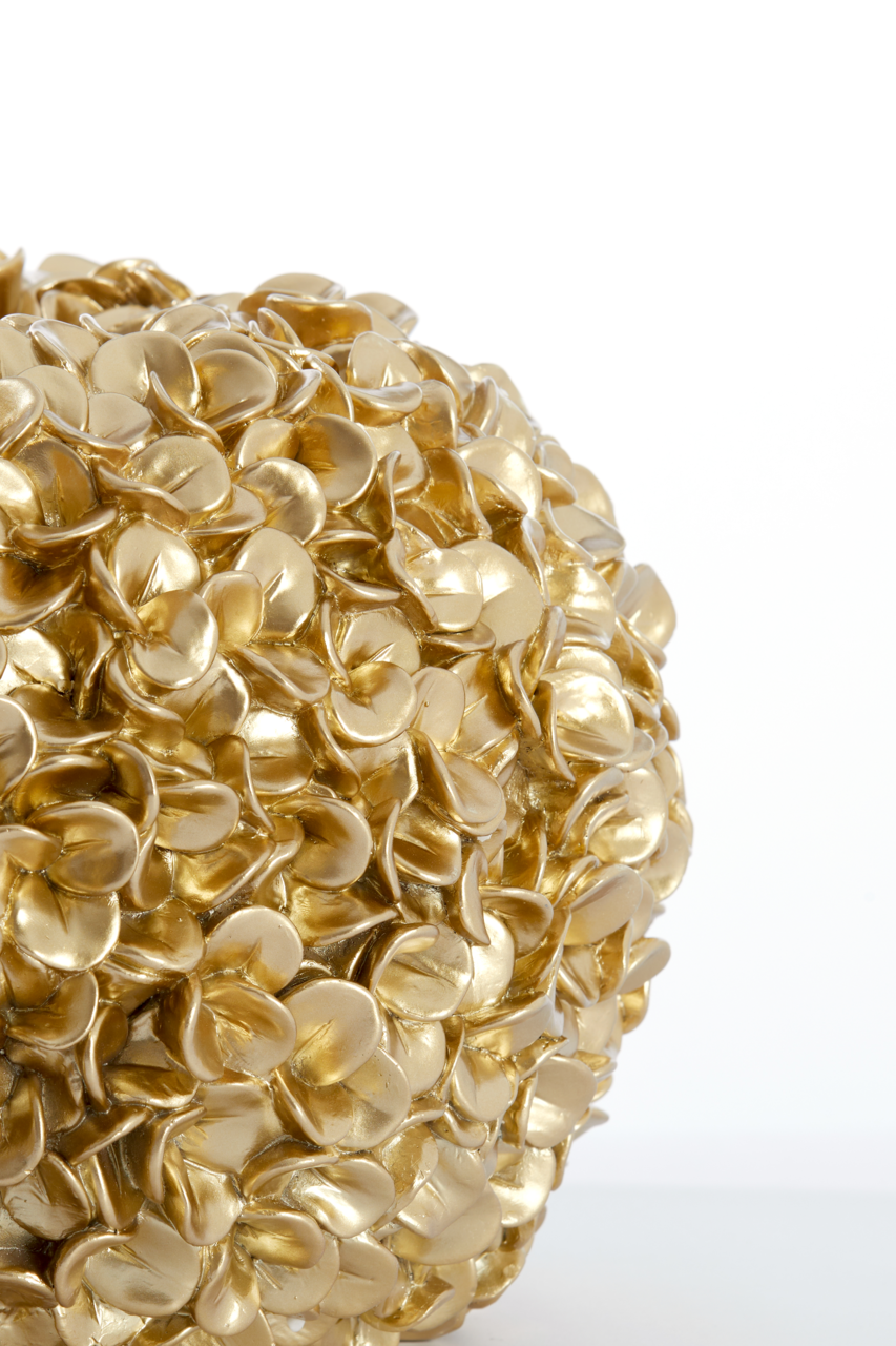 Nahaufnahme einer goldenen Vase mit blütenförmiger Struktur, seitliche Perspektive.