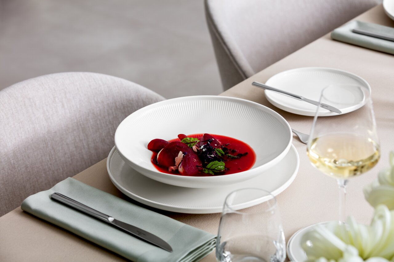 Suppenteller Afina 25cm mit roter Suppe und Garnitur, seitliche Perspektive auf einem gedeckten Tisch