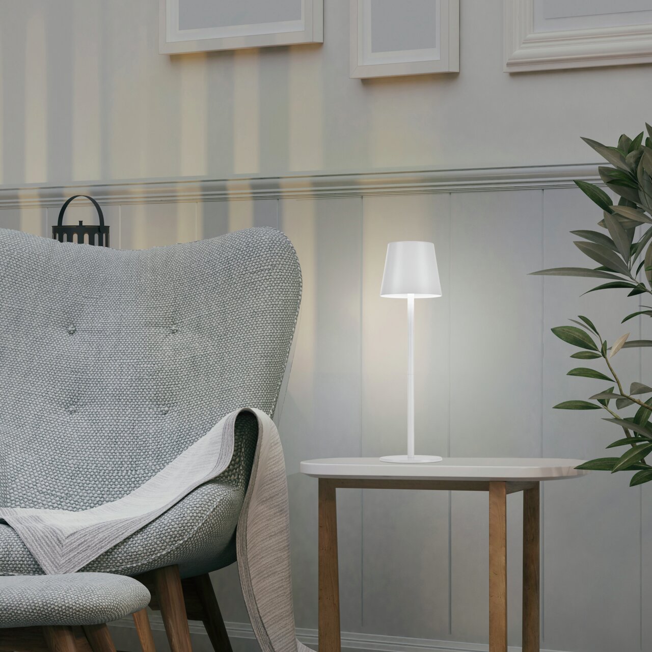 Moderne Akku-Tischleuchte EURIA in einem gemütlichen Wohnzimmer, seitliche Perspektive.