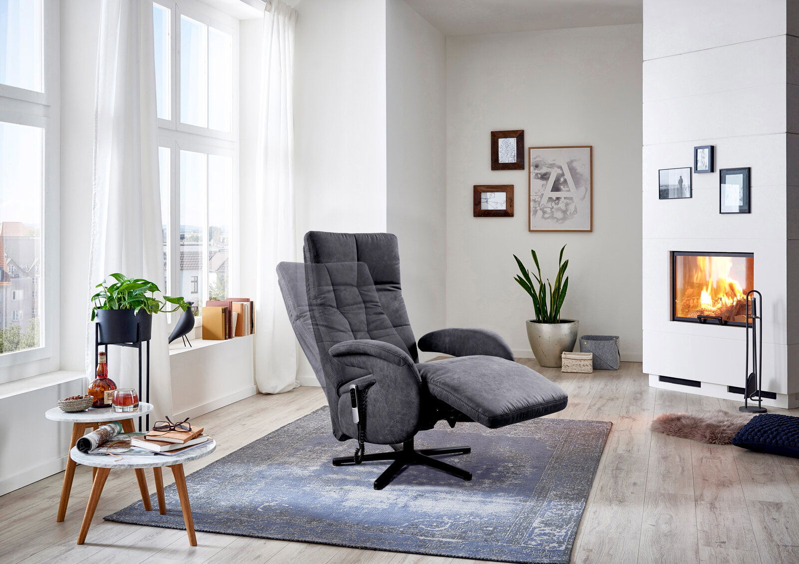 Grauer Sessel in einem modernen Wohnzimmer mit Kamin, von der Seite betrachtet.