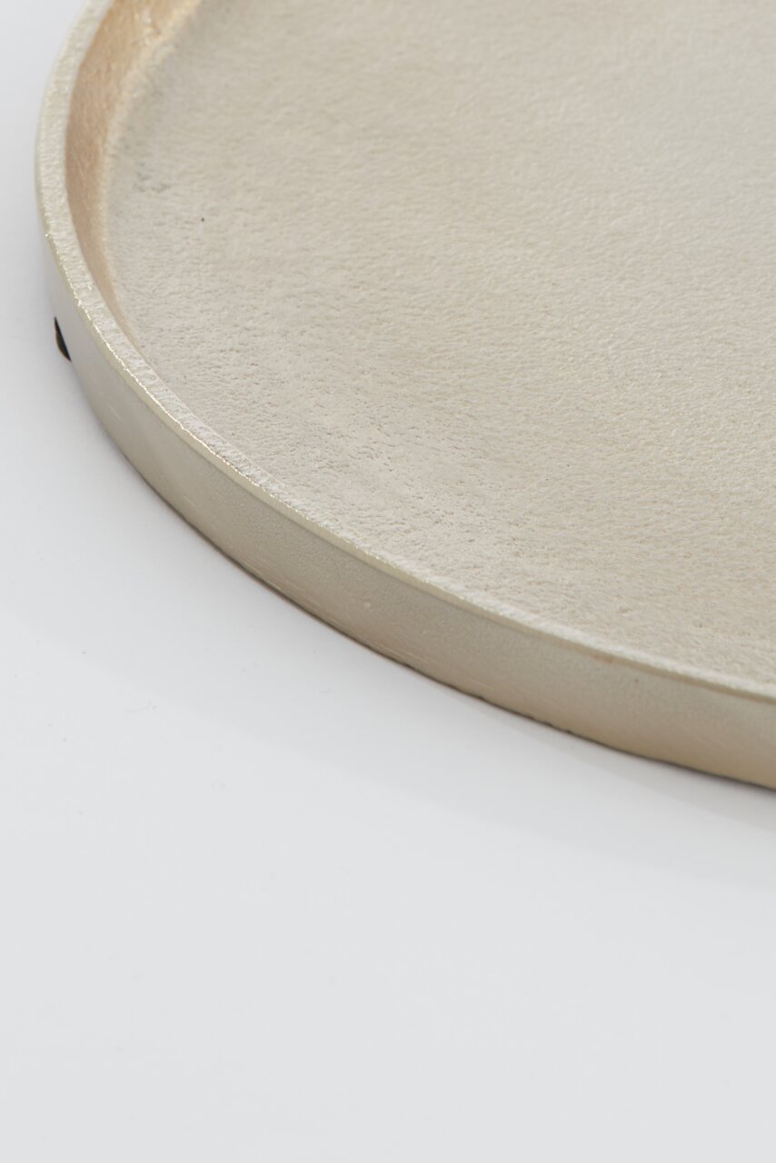 Nahaufnahme einer runden, flachen Schale mit glatter, metallischer Oberfläche, seitliche Perspektive.