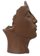 Seitenansicht eines Blumentopfs in Form eines antiken Kopfes mit rustikaler, brauner Oberfläche.