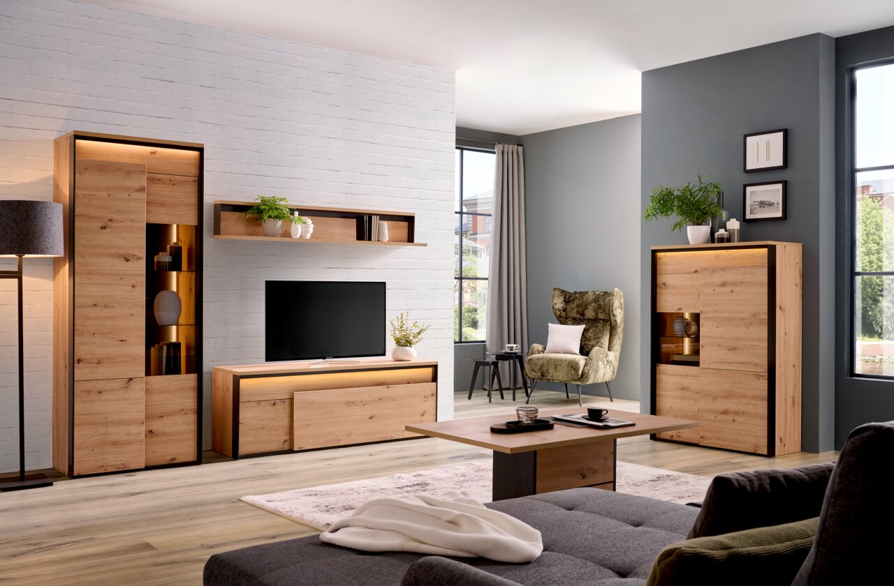 Wohnzimmer mit modernen Holzmöbeln, darunter ein TV-Lowboard, ein Wandboard, ein Highboard und ein Couchtisch, aus einer frontalen Perspektive.