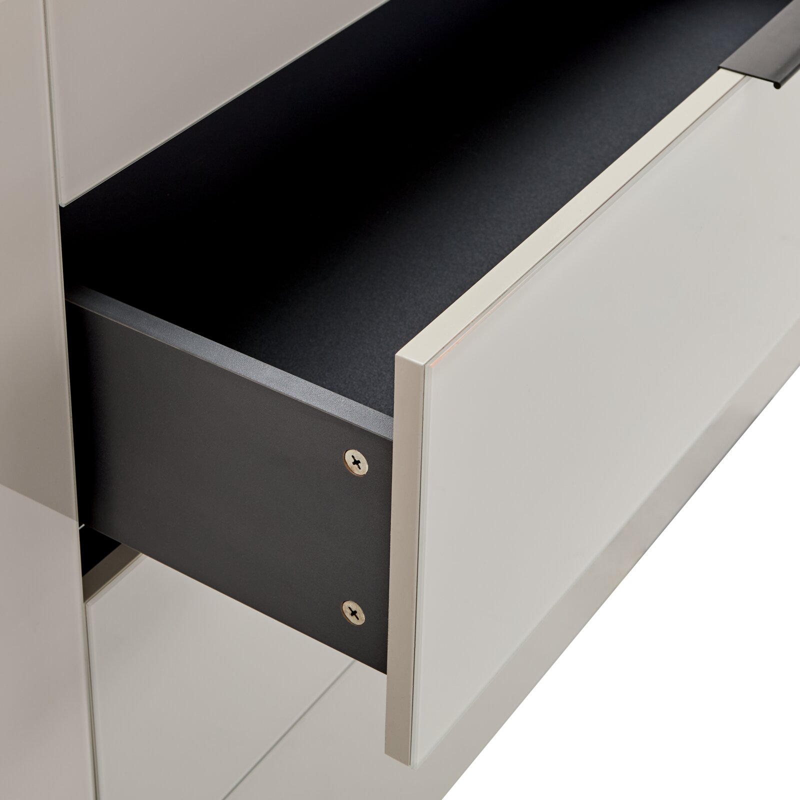 Ausgezogene Schublade eines modernen weißen Schranks/Sideboards mit schwarzem Innenraum und schwarzer Schubladenseite, Detailansicht in schräger Seitenperspektive von vorn