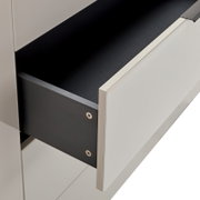 Ausgezogene Schublade eines modernen weißen Schranks/Sideboards mit schwarzem Innenraum und schwarzer Schubladenseite, Detailansicht in schräger Seitenperspektive von vorn