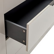 Ausgezogene Schublade eines modernen weißen Schranks/Sideboards mit schwarzem Innenraum und schwarzer Schubladenseite, Detailansicht in schräger Seitenperspektive von vorn