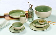 Frühstücksset in hellgrün und dunkelgrün mit Tassen, Schalen und Tellern, von oben betrachtet.