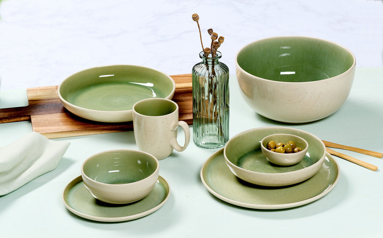 Frühstücksset in hellgrün und dunkelgrün mit Tassen, Schalen und Tellern, von oben betrachtet.