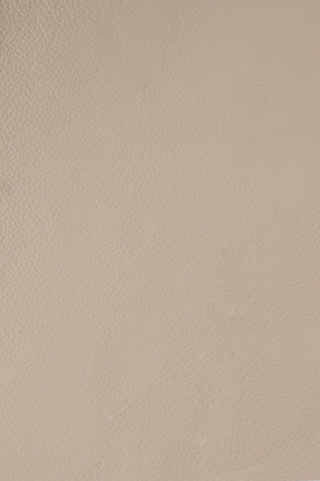 Nahaufnahme einer beigen Lederstruktur, von oben betrachtet.