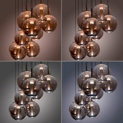Moderne LED-Pendelleuchte mit mehreren kugelförmigen, rauchgrauen Glaskörpern, aus der Perspektive von unten betrachtet.