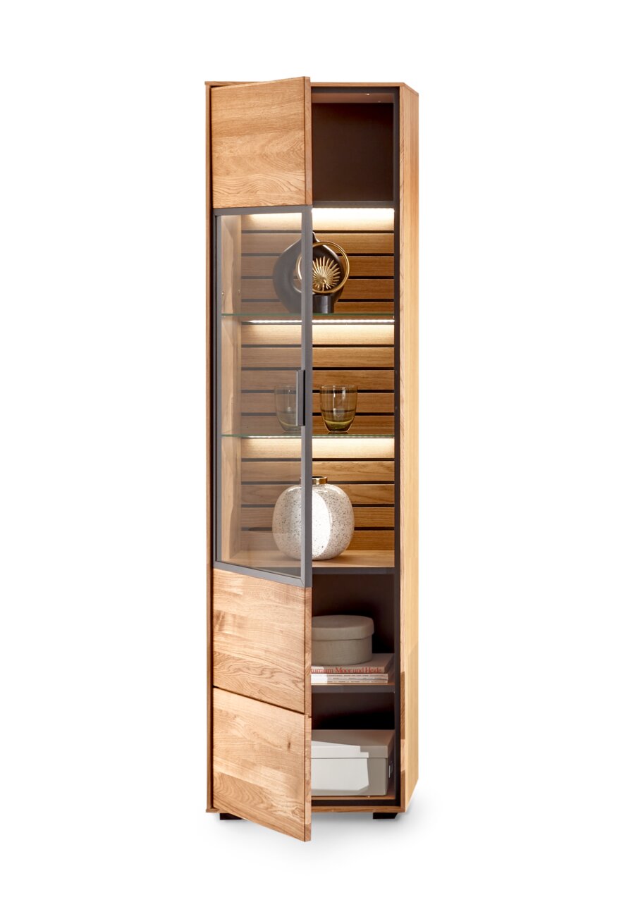 Houten vitrinekast met glazen deur, zijaanzicht, verlichte planken met decoraties.