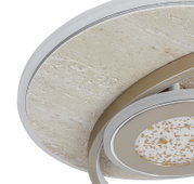 Detailaufnahme aus leicht schräger Untersicht einer runden Deckenleuchte mit strukturierter Steinoptik, silberfarbenem Rand und modernem Ring-Design mit goldgesprenkeltem Diffusor