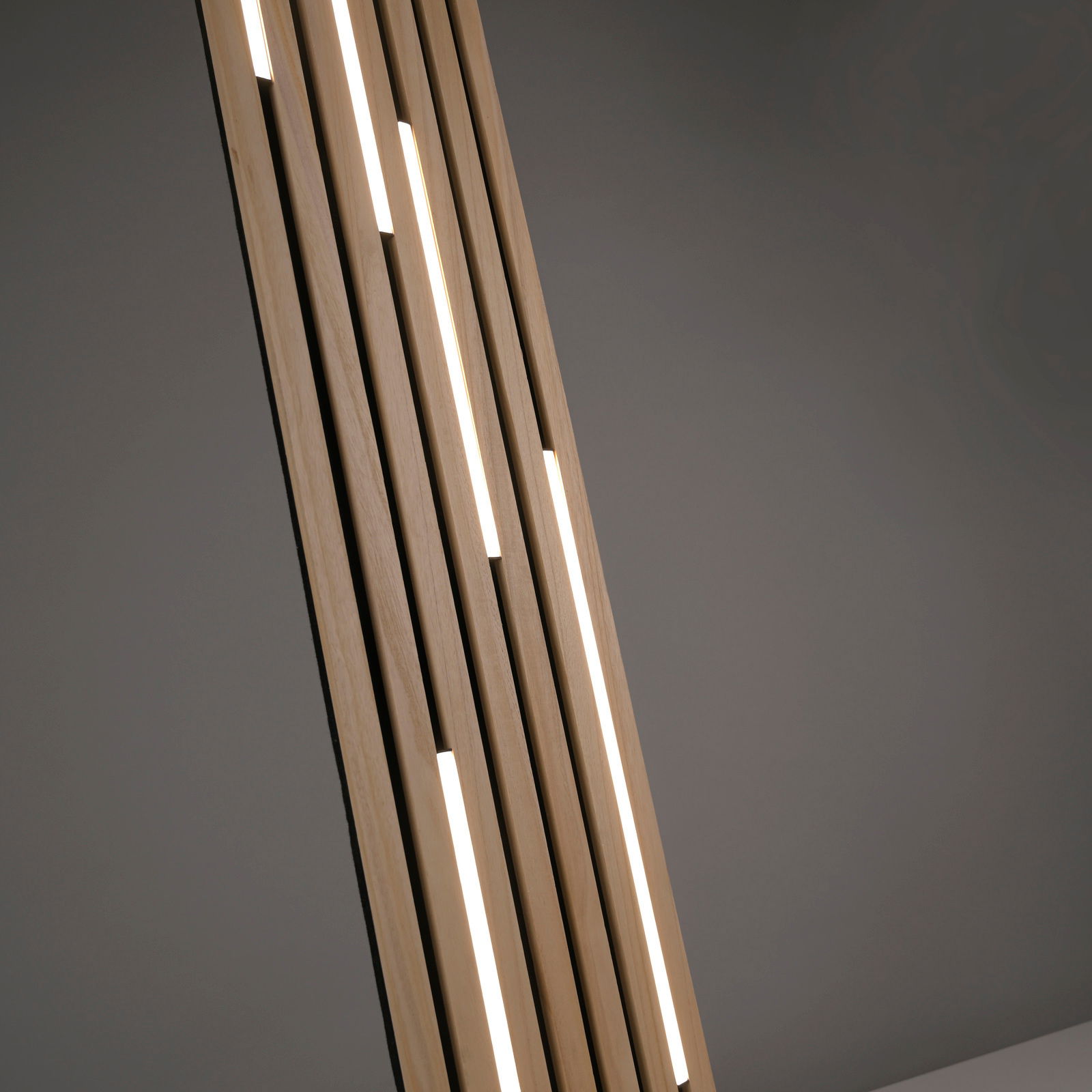 Nahaufnahme einer modernen LED-Stehleuchte mit vertikalen Holzstreben und integrierten Leuchtstreifen, seitliche Perspektive.