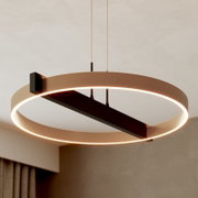 Moderne ronde LED-hanglamp in bronskleurig metaal met warmwit licht, schuin van onderen bekeken in een stijlvol interieur