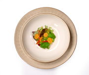 Beiger Teller Omara 20cm mit floralem Muster, von oben fotografiert, serviert mit einem frischen Salat.