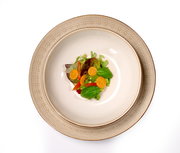 Beiger Teller Omara 20cm mit floralem Muster, von oben fotografiert, serviert mit einem frischen Salat.