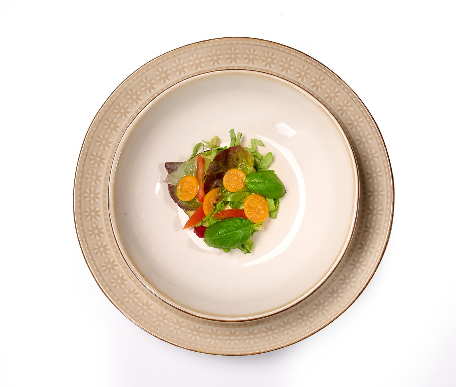 Beiger Teller Omara 20cm mit floralem Muster, von oben fotografiert, serviert mit einem frischen Salat.