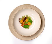 Beiger Teller Omara 20cm mit floralem Muster, von oben fotografiert, serviert mit einem frischen Salat.