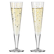 Zwei elegante Champagnergläser mit goldenen und schwarzen Sternmotiven, gefüllt mit sprudelndem Getränk, frontal abgebildet.