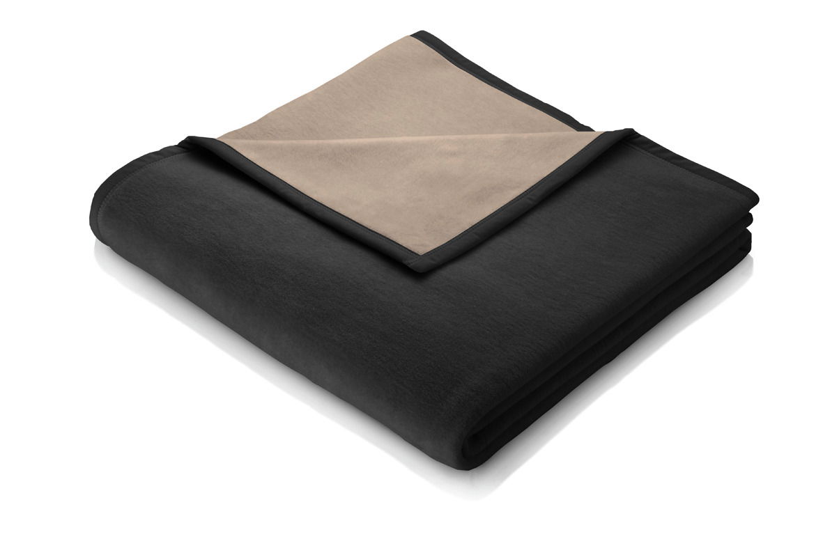 Gefaltete Decke in Schwarz und Beige, von schräg oben fotografiert.