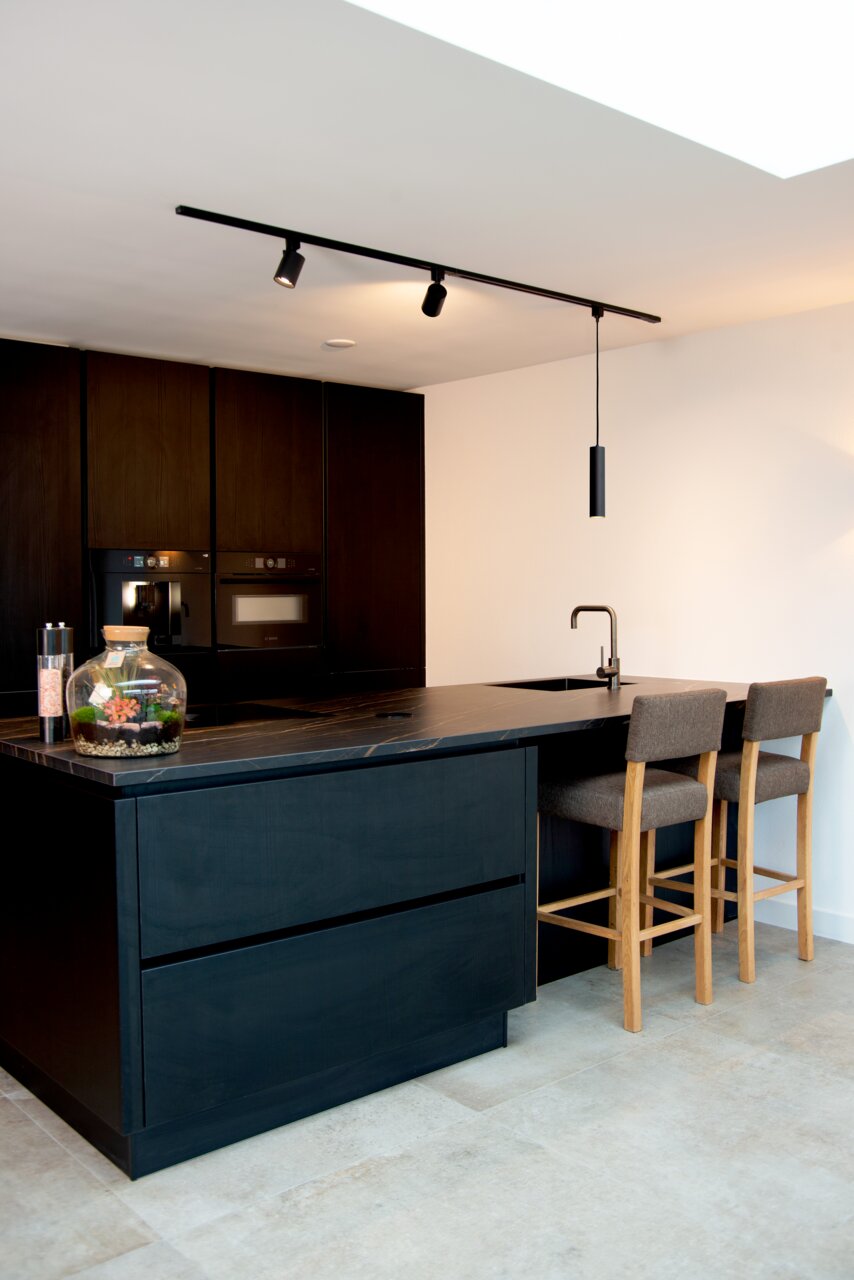 Schwarzer Strahler NIGEL von Lucide, montiert an einer Decke in einer modernen Küche, seitliche Perspektive.