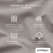 Nahaufnahme eines Spannbettlakens in Beige, dehnbar, blickdicht und straff, aus 95% Bio-Baumwolle und 5% Elasthan, geeignet für Maschinenwäsche bis 60 Grad, atmungsaktiv und robust, gestrickter Stoff für T-Shirt Feeling.