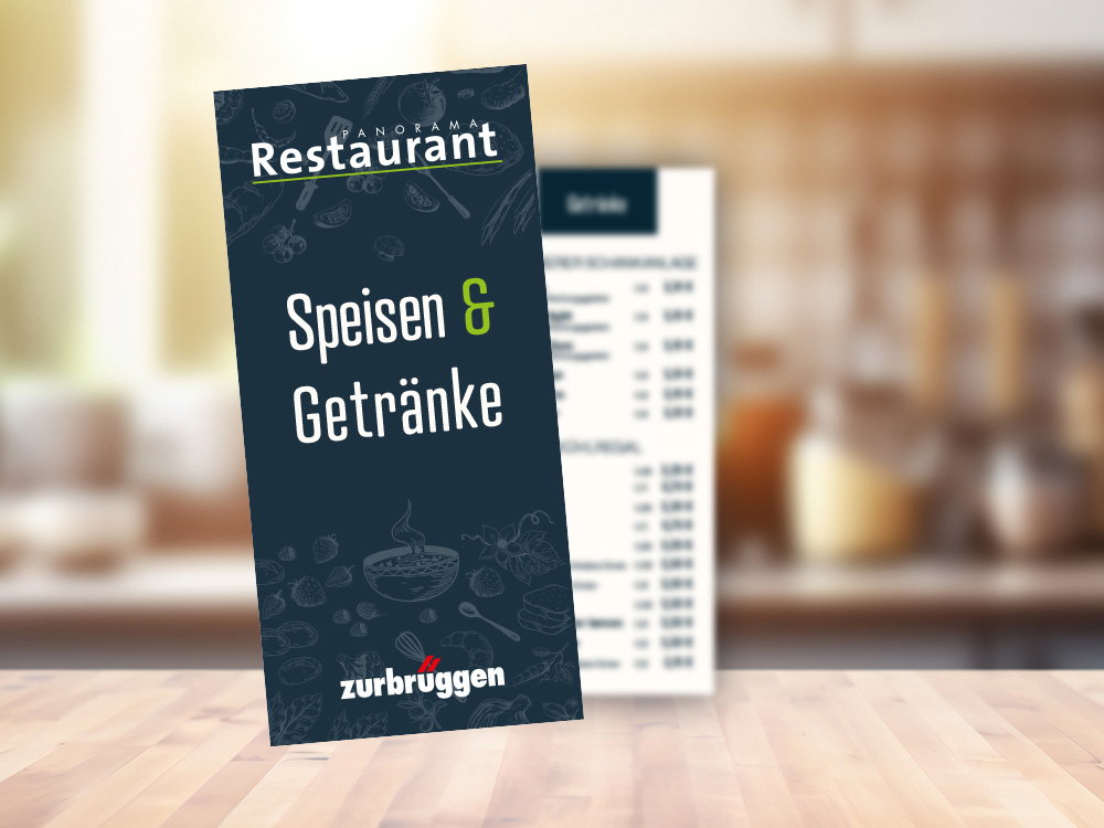 Speisekarte „Speisen & Getränke“ des Panorama Restaurants auf Tresen vor unscharfem Küchenhintergrund.