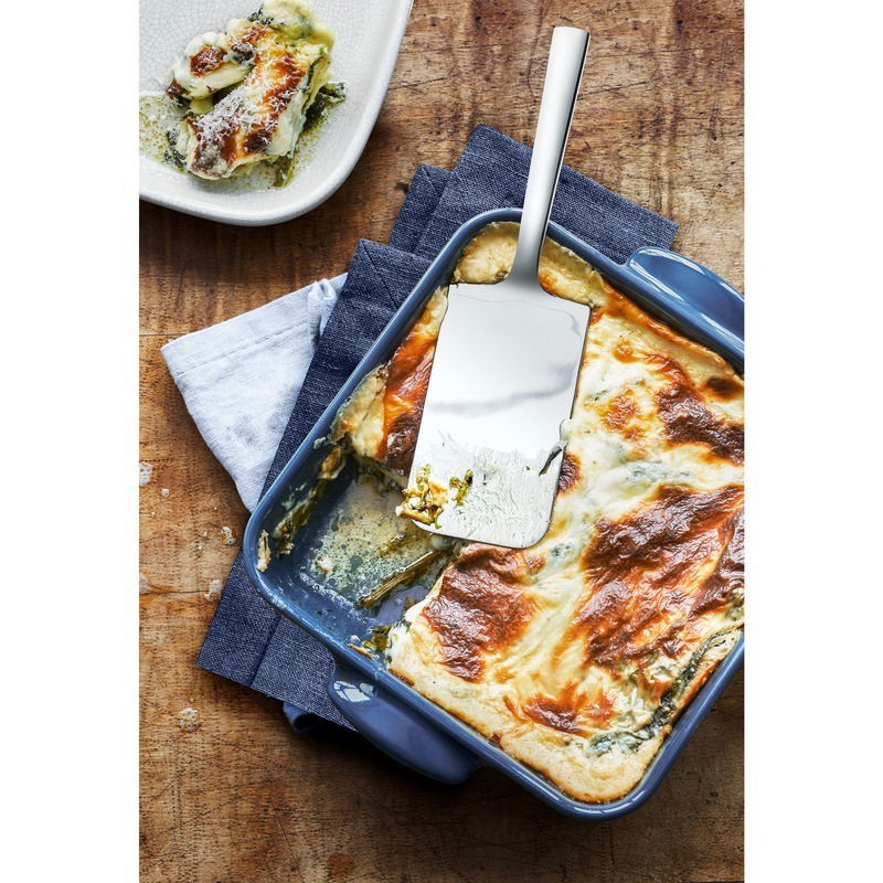 Lasagneheber aus Edelstahl in einer blauen Auflaufform mit Lasagne, von oben fotografiert.