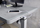 Moderner E-Schreibtisch mit Glasoberfläche, USB-Anschluss und Smartphone, seitliche Perspektive