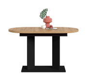 Ovaler Esstisch mit heller Holzplatte und schwarzem Säulenfuß, frontale Ansicht; dekoriert mit roter Vase, grünem Blatt, weißer Tasse und Macarons auf Tablett.