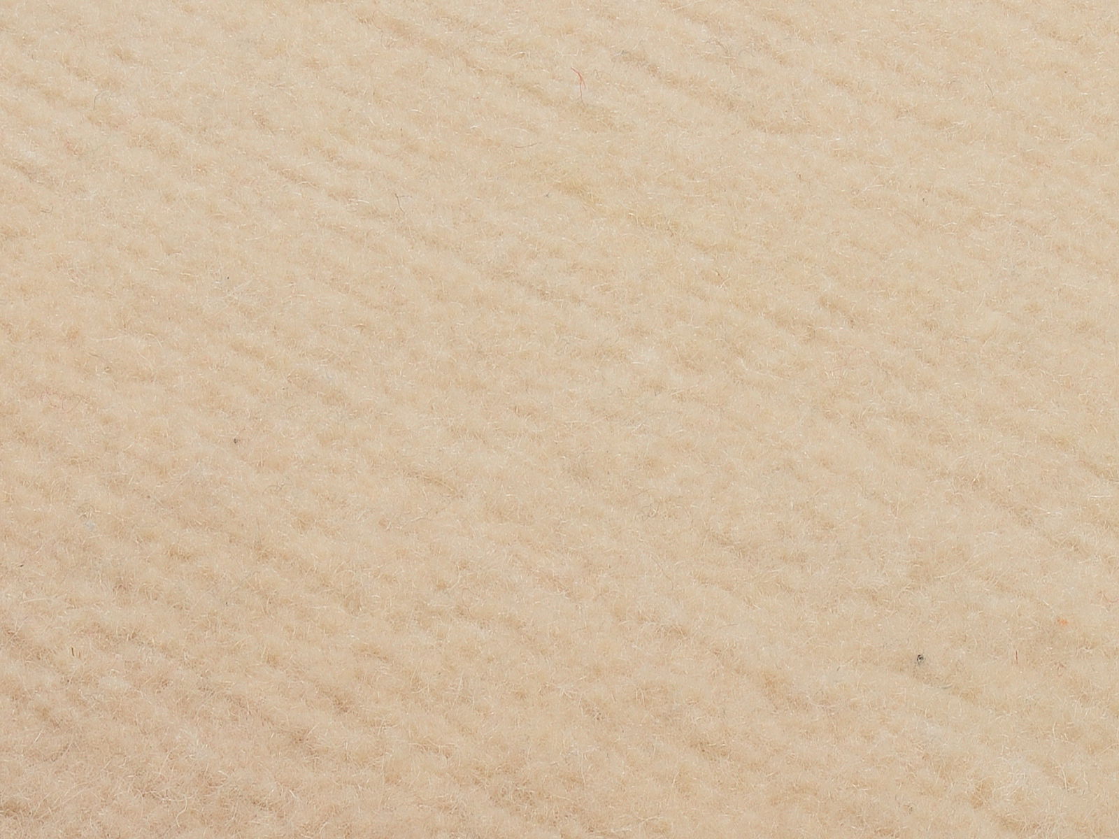 Nahaufnahme eines beigen Wollteppichs mit weicher Textur