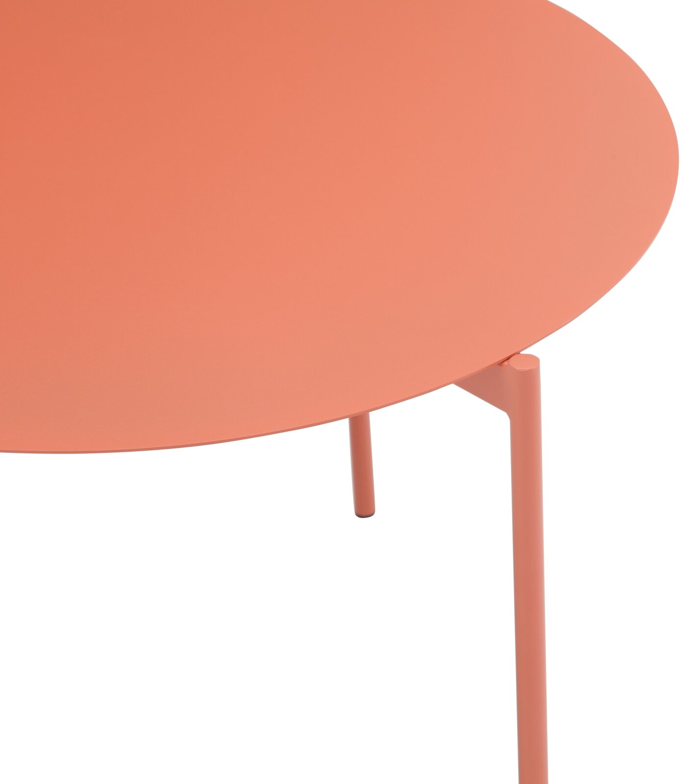 Ronde bijzettafel in koraalkleur, close-up van bovenaf met de nadruk op het tafelblad en een tafelpoot.