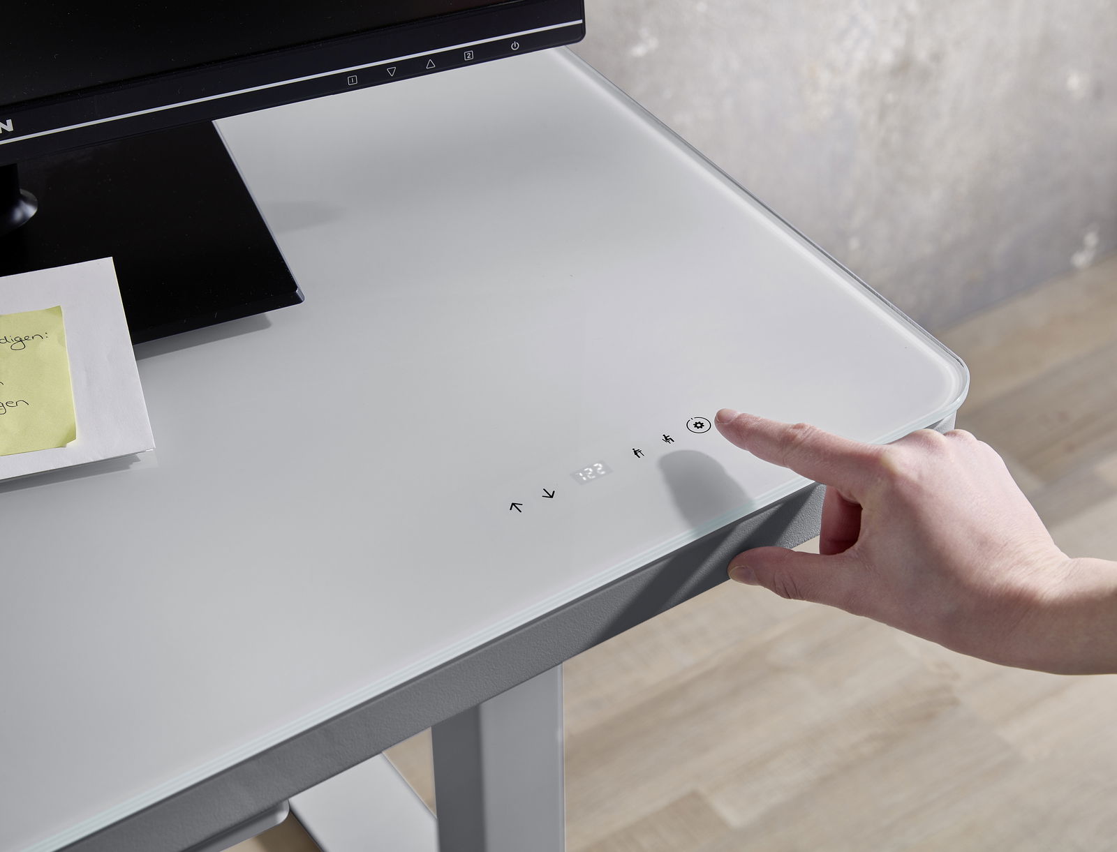 Moderner E-Schreibtisch mit Glasoberfläche und Touch-Bedienfeld, seitliche Perspektive