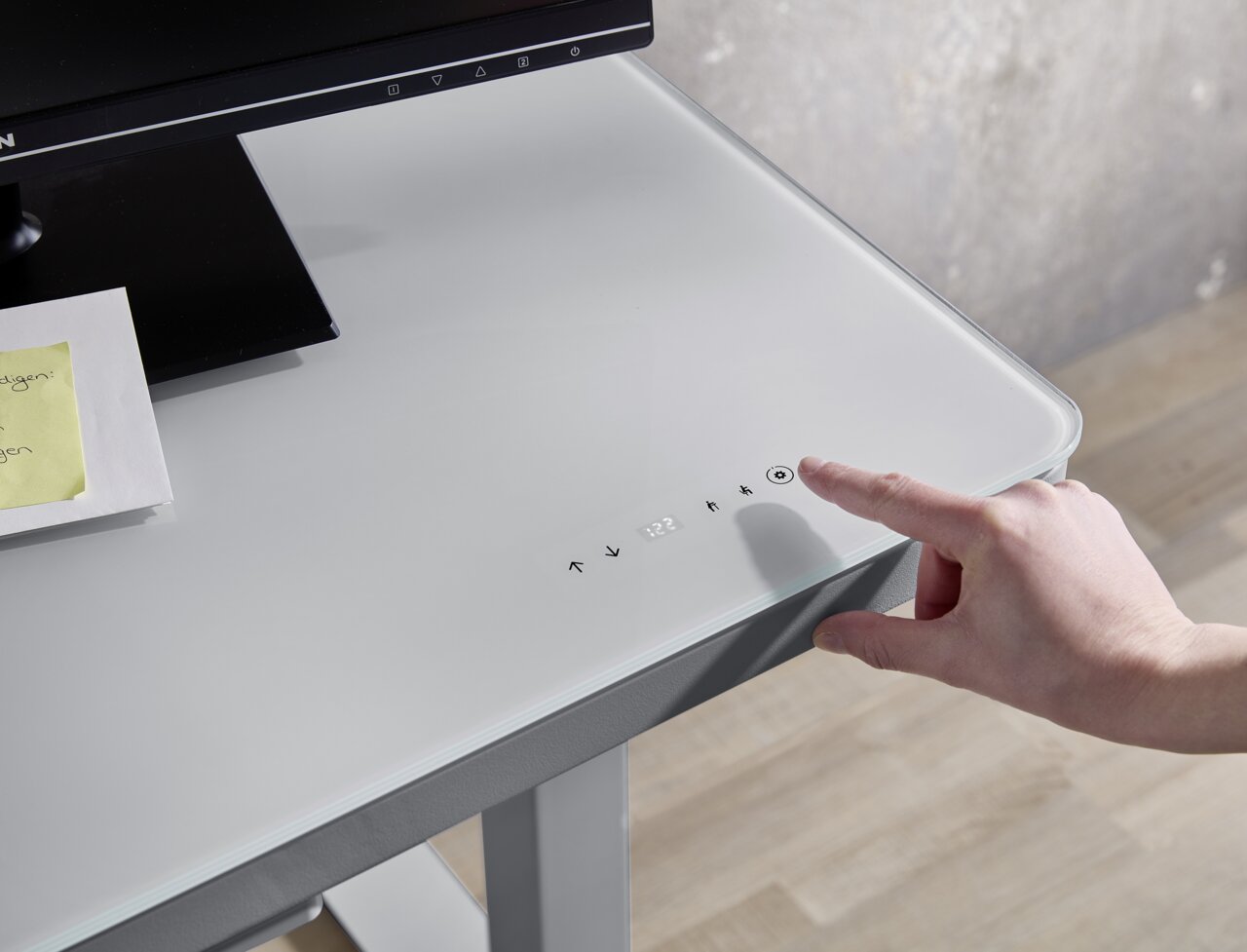 Moderner E-Schreibtisch mit Glasoberfläche und Touch-Bedienfeld, seitliche Perspektive