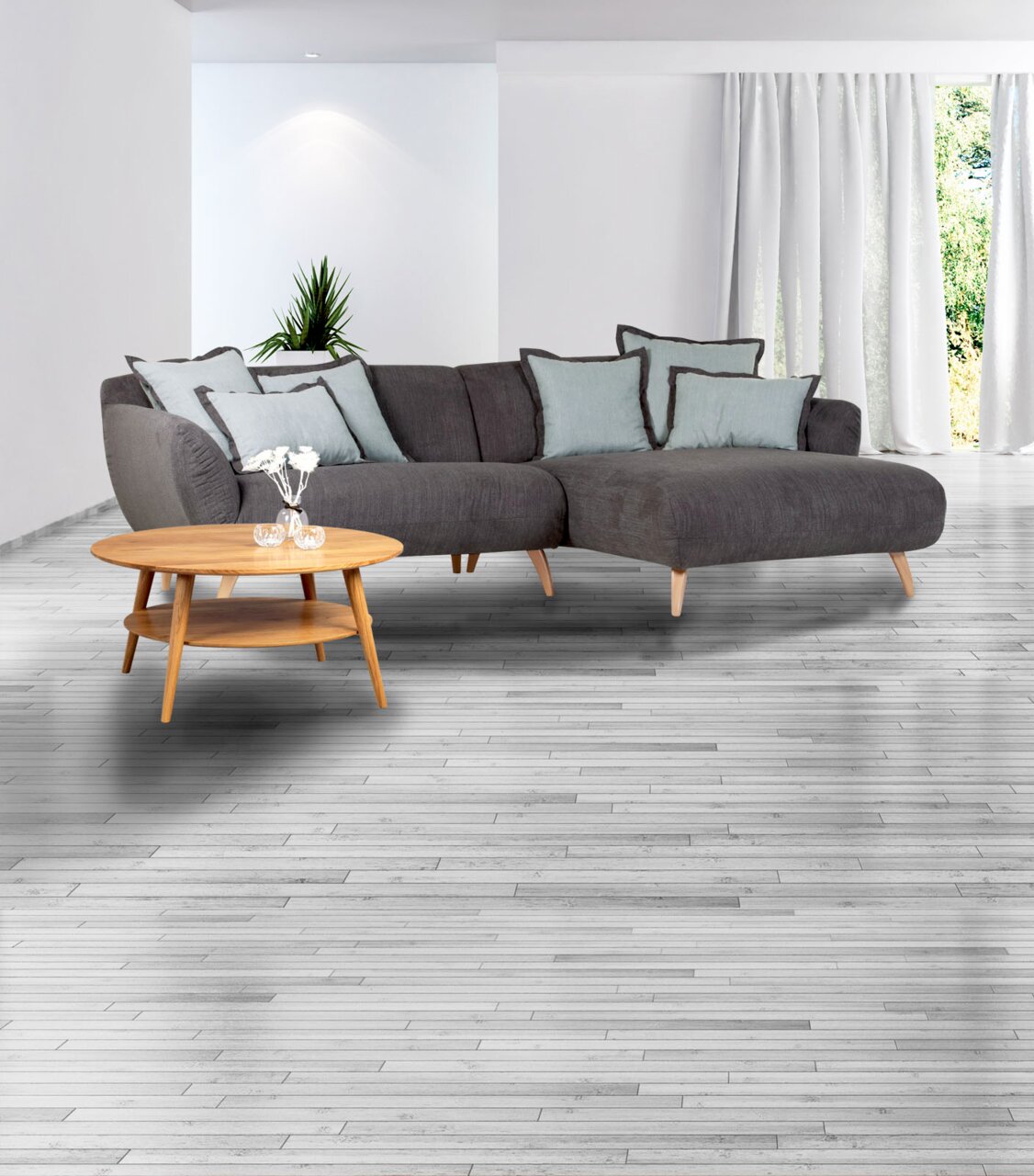Graues Ecksofa mit hellblauen Kissen und einem runden Holzcouchtisch in einem modernen Wohnzimmer, seitliche Perspektive.