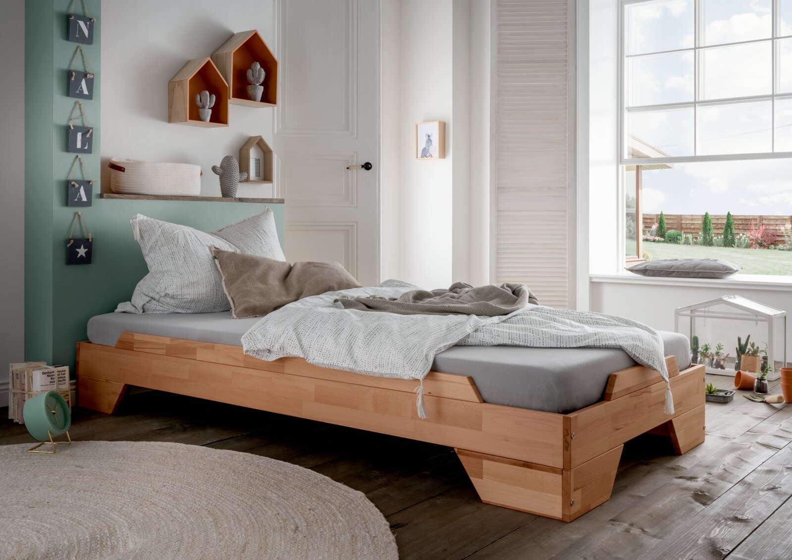 Holzstapelbett in einem gemütlichen Schlafzimmer mit Tageslicht, seitliche Perspektive
