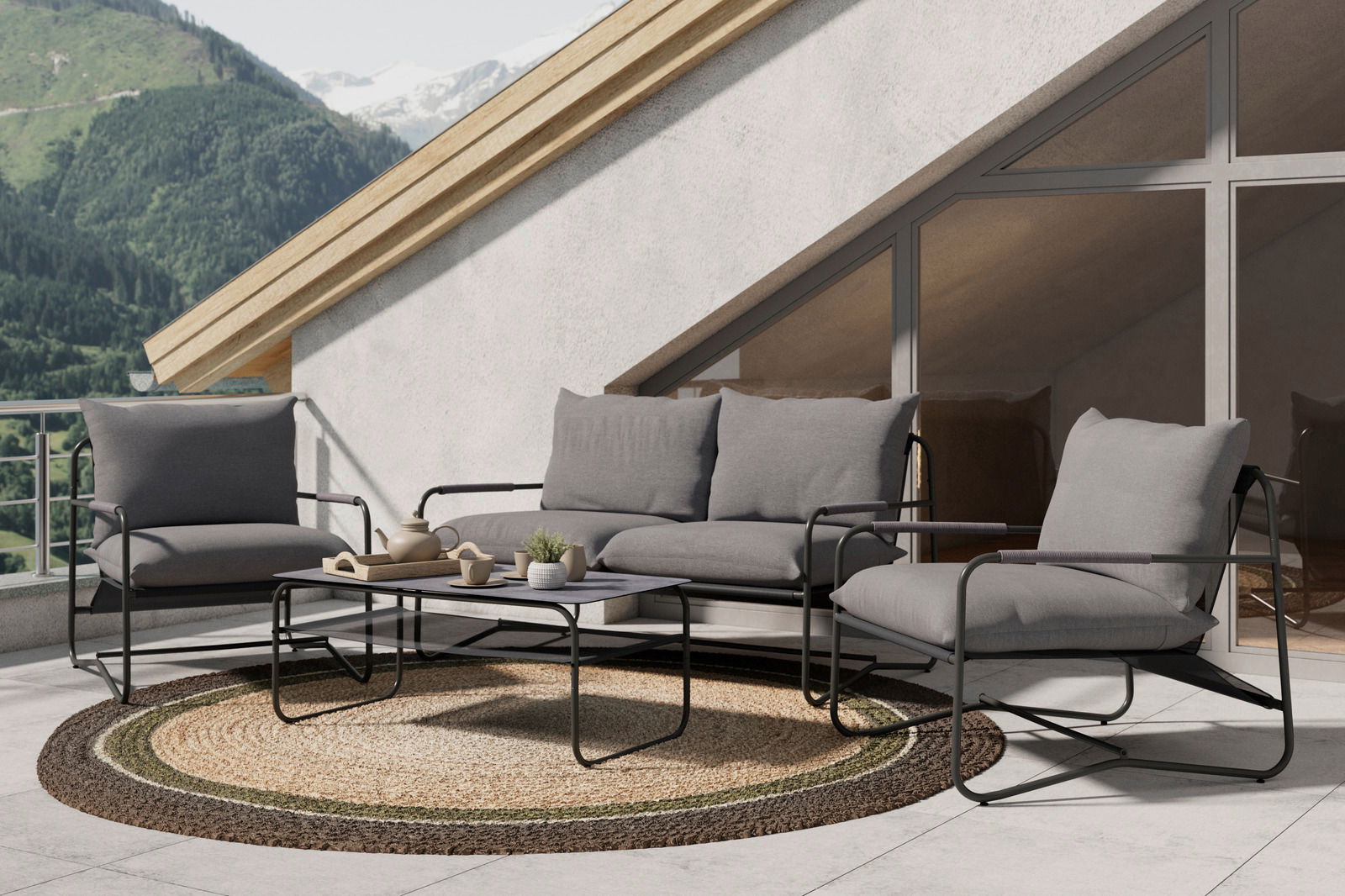 Moderne Loungegarnitur auf einer Terrasse mit Bergblick, bestehend aus einem Sofa, zwei Sesseln und einem Tisch, aus der seitlichen Perspektive fotografiert.