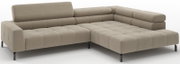 Beiges L-förmiges Ecksofa mit breiter Ottomane rechts, gesteppten Sitz- und Rückenpolstern sowie schwarzen Metallfüßen, in schräger Vorderansicht freigestellt auf weißem Hintergrund.