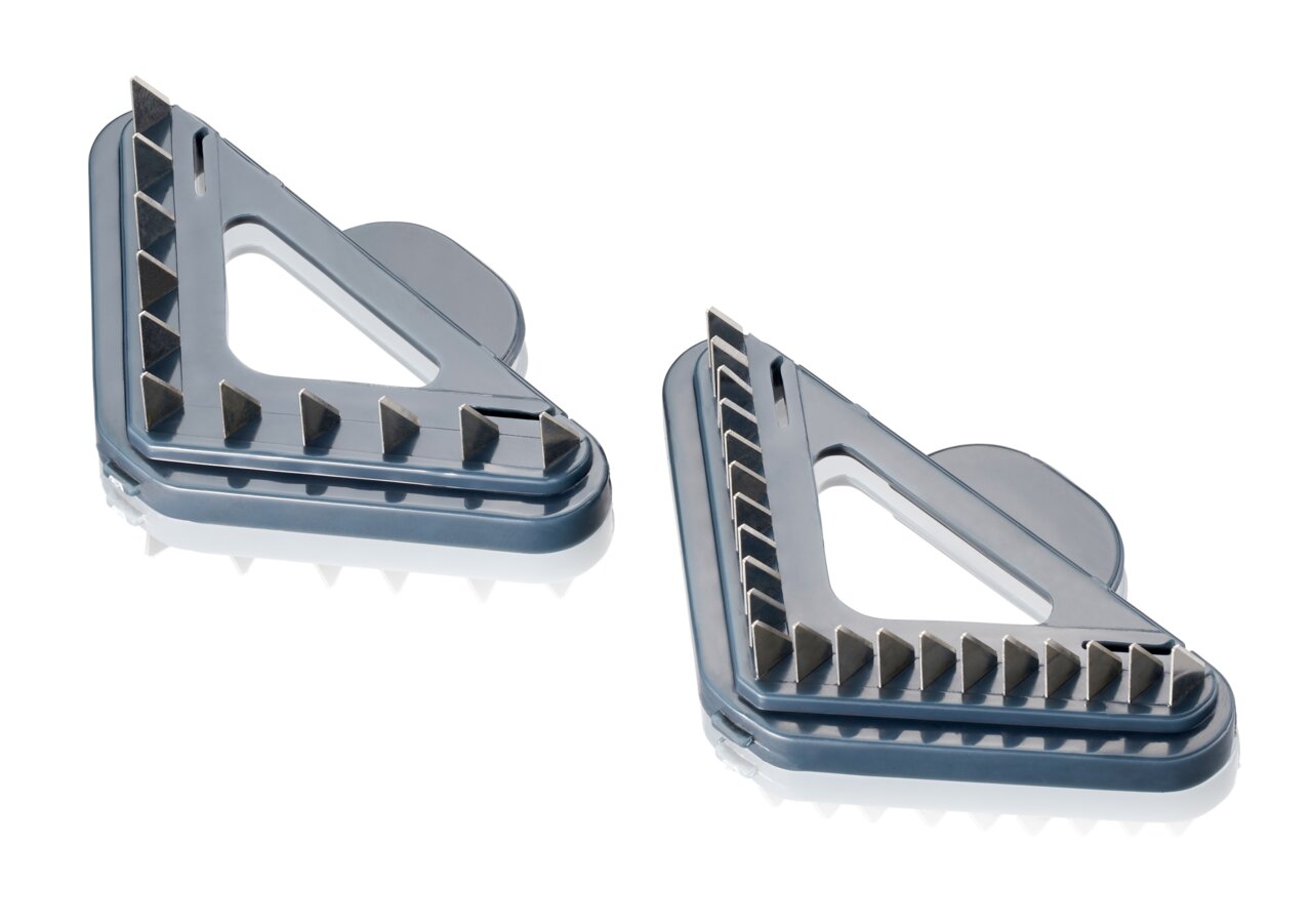 Zwei V-Hobel Julienne-Einsätze in dreieckiger Form, aus der Vogelperspektive fotografiert, mit scharfen Klingen für präzises Schneiden.
