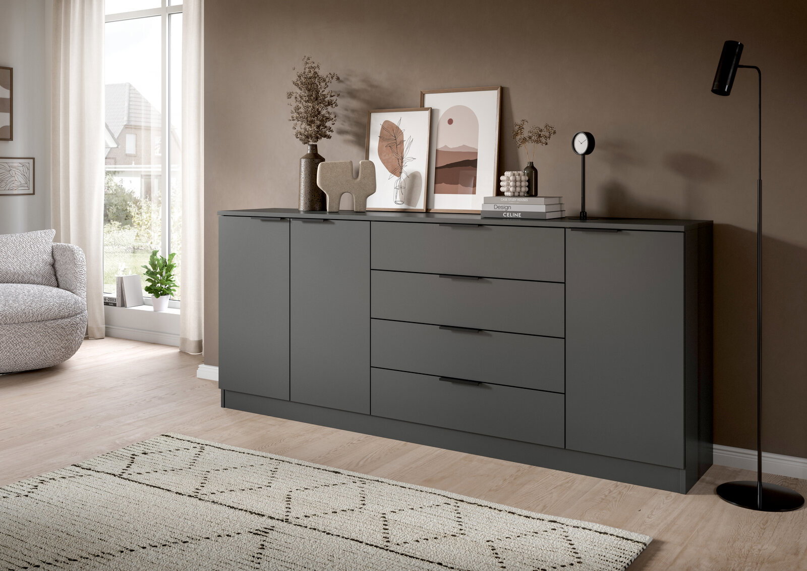 MID.YOU Kommode KOPENHAGEN Moderne, matte dunkelgraue Sideboard-Kommode mit zwei Türen und vier Schubladen, dekoriert mit Bilderrahmen, Vasen und Uhr, im Wohnzimmer – Frontansicht in leichter Schrägperspektive von links.