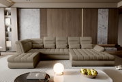 Beiges, modernes U-förmiges Polstersofa mit tiefen Sitzflächen und Steppung in einem stilvollen Wohnzimmer, frontale Perspektive