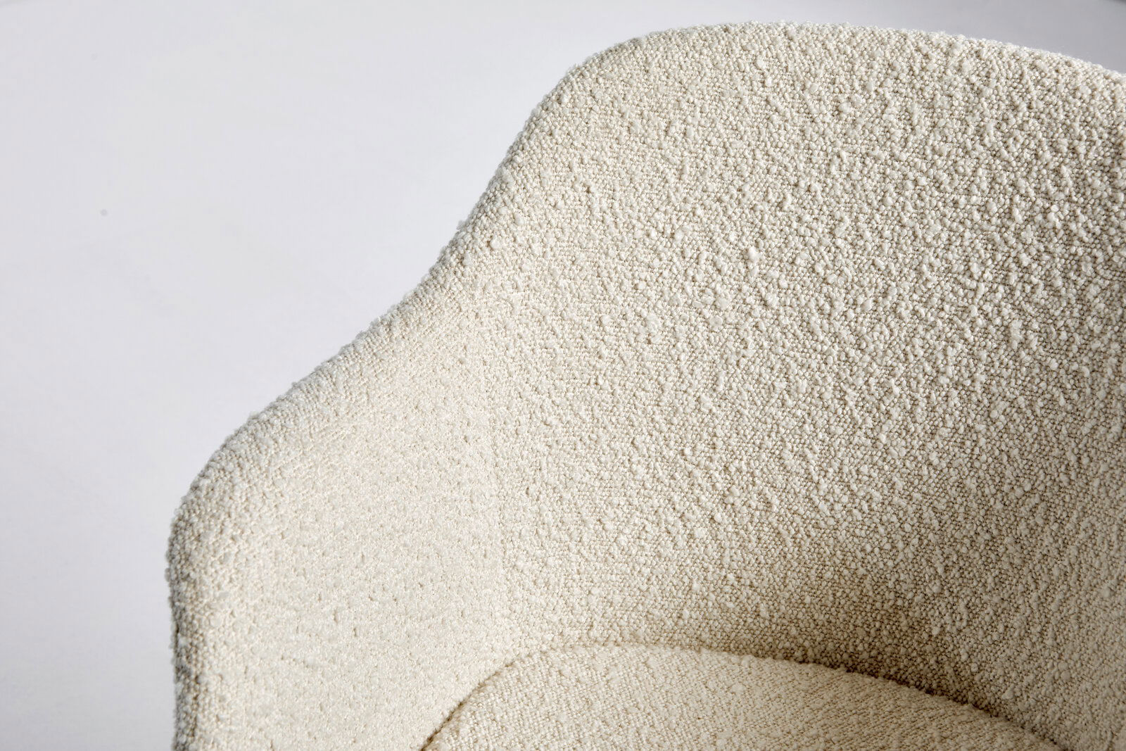 Nahaufnahme der strukturierten Oberfläche eines cremefarbenen Stuhls aus der Vogelperspektive.