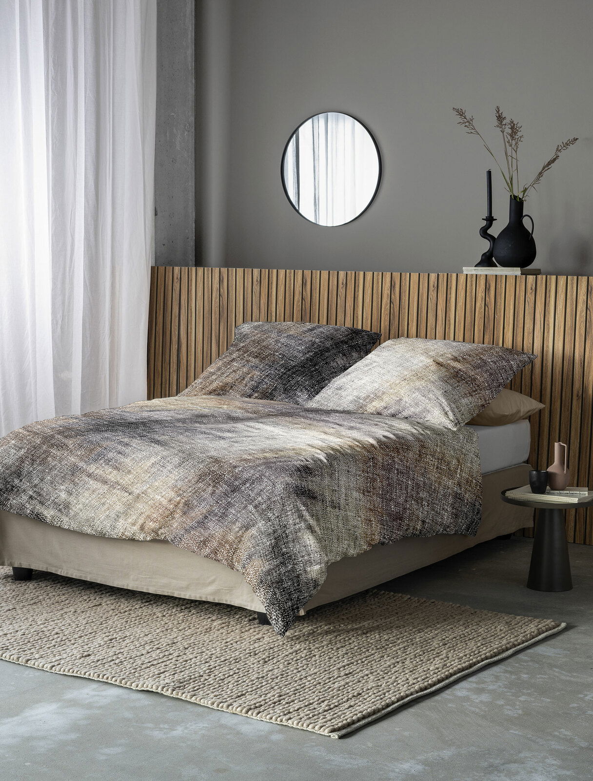 Bettwäsche-Set in natürlichen Erdtönen auf einem Bett mit Holzrückwand, seitliche Perspektive.