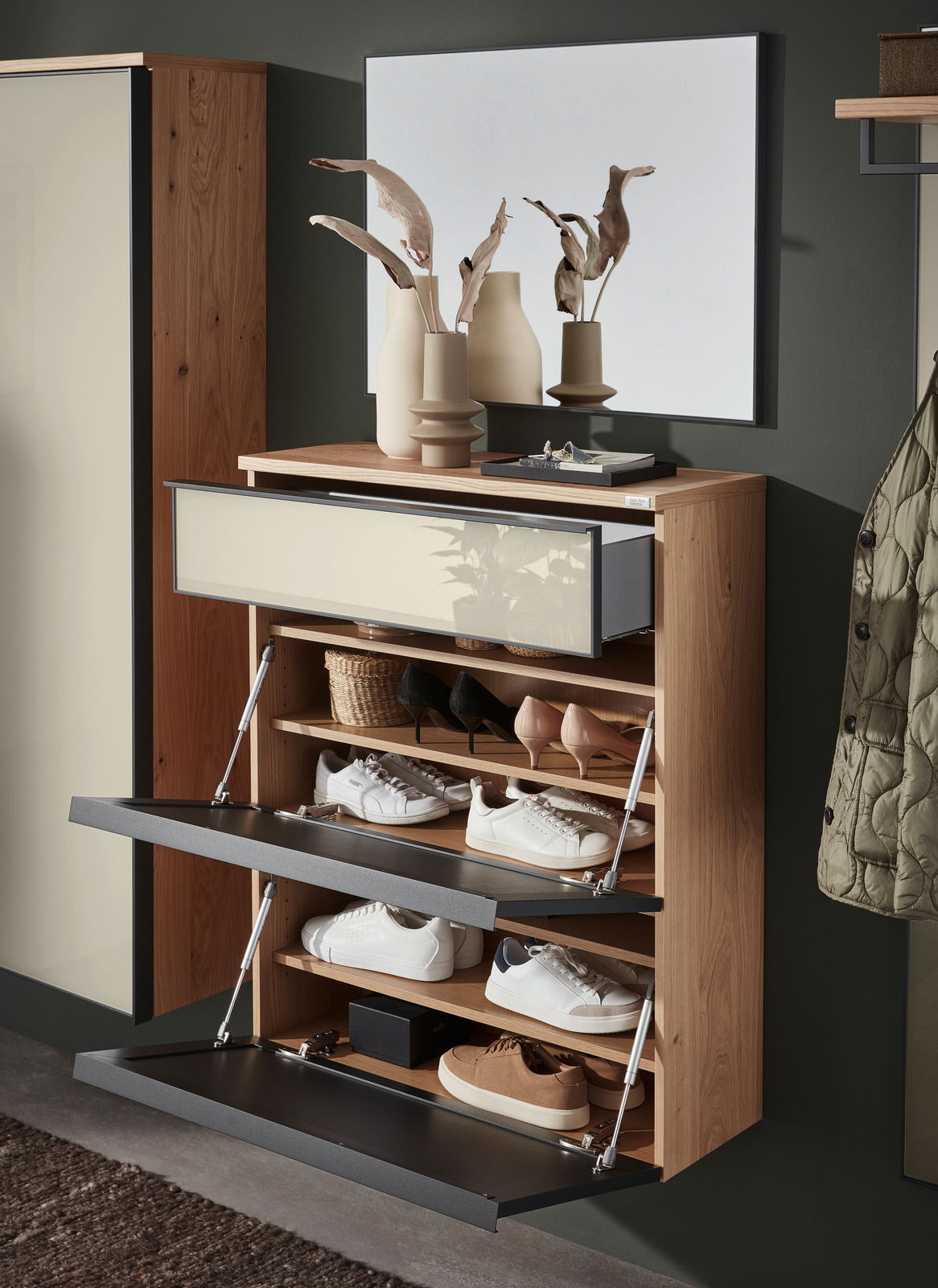 Moderner Hängeschuhschrank aus Holz mit mehreren offenen Klappen, gefüllt mit verschiedenen Schuhen, in einer stilvollen Raumumgebung. Perspektive von vorne.