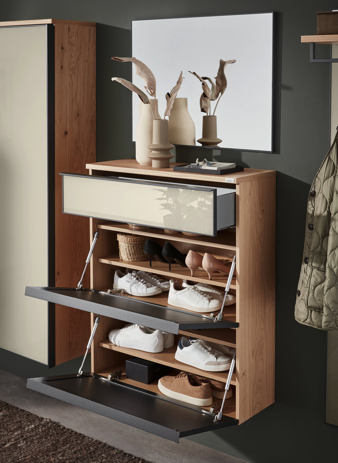 Moderner Hängeschuhschrank aus Holz mit mehreren offenen Klappen, gefüllt mit verschiedenen Schuhen, in einer stilvollen Raumumgebung. Perspektive von vorne.