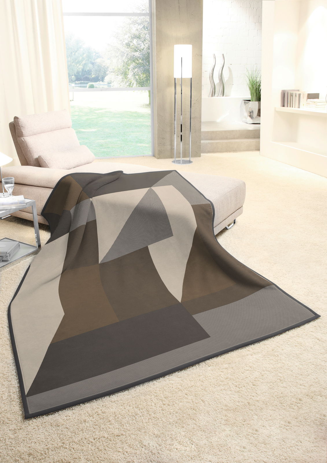 biederlack Wohndecke COTTON HOME Moderne Wohndecke 150x200cm in geometrischem Design, drapiert auf einem Sofa in einem hellen Wohnzimmer mit Blick auf den Garten.